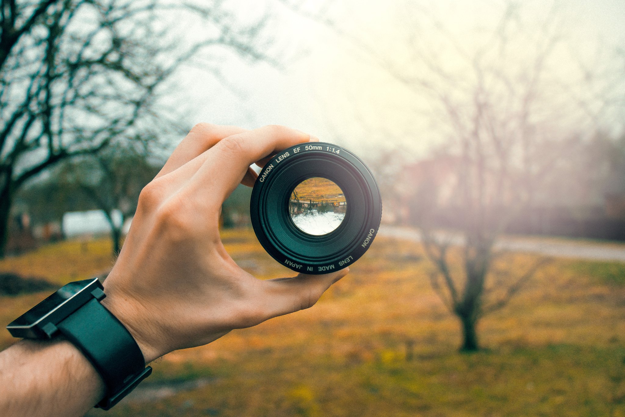 Photographer Holding A Camera Lens In Landscape